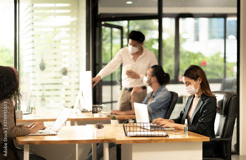 Social distance office with business team wear face mask as new normal life