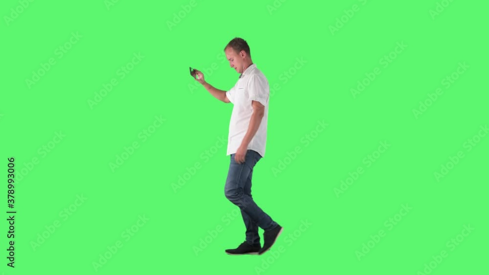 Happy business man taking selfie portrait with smart phone while walking. Side view. Full body on green screen chroma key background. Happy business man taking selfie portrait with smart phone while walking. Side view. Full body on green screen chroma key background.