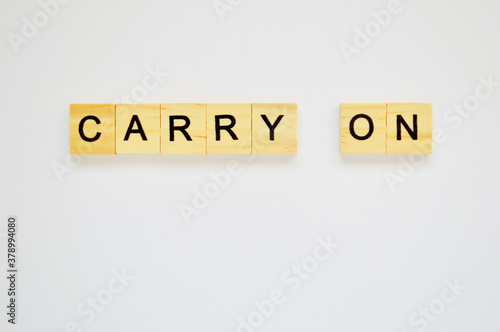 Word carry on. Wooden blocks with lettering on top of white background. Top view of wooden blocks with letters on white surface