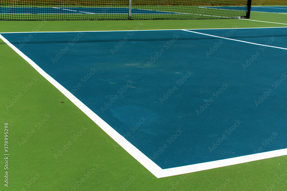 Recreational sport of pickleball court in Michigan, USA looking at an empty blue and green new court at a outdoor park. Ground View.