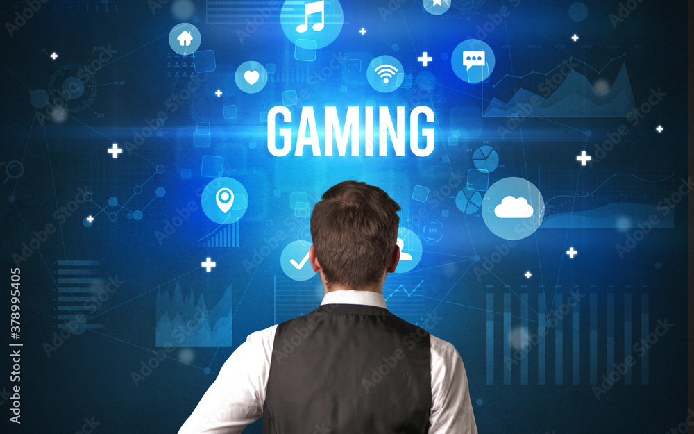 Rear view of a businessman with GAMING inscription, modern technology concept Rear view of a businessman with GAMING inscription, modern technology concept