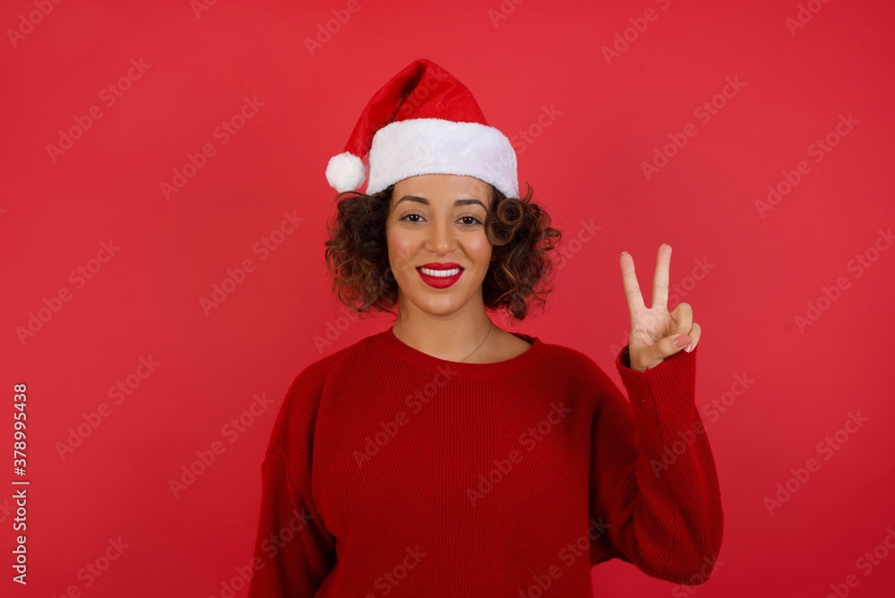 Young caucasian woman standing against gray wall showing and pointing up with fingers number two while smiling confident and happy. Young caucasian woman standing against gray wall showing and pointing up with fingers number two while smiling confident and happy.