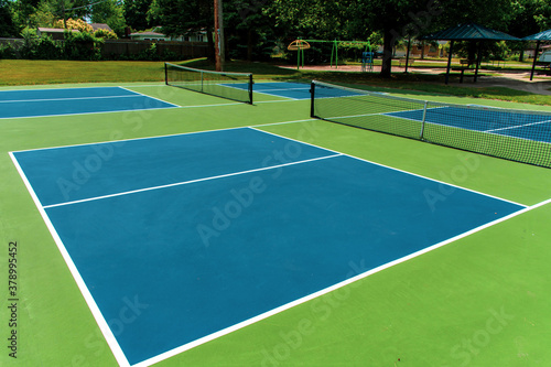 Recreational sport of pickleball court in Michigan, USA looking at an empty blue and green new court at a outdoor park. © KingmaPhotos