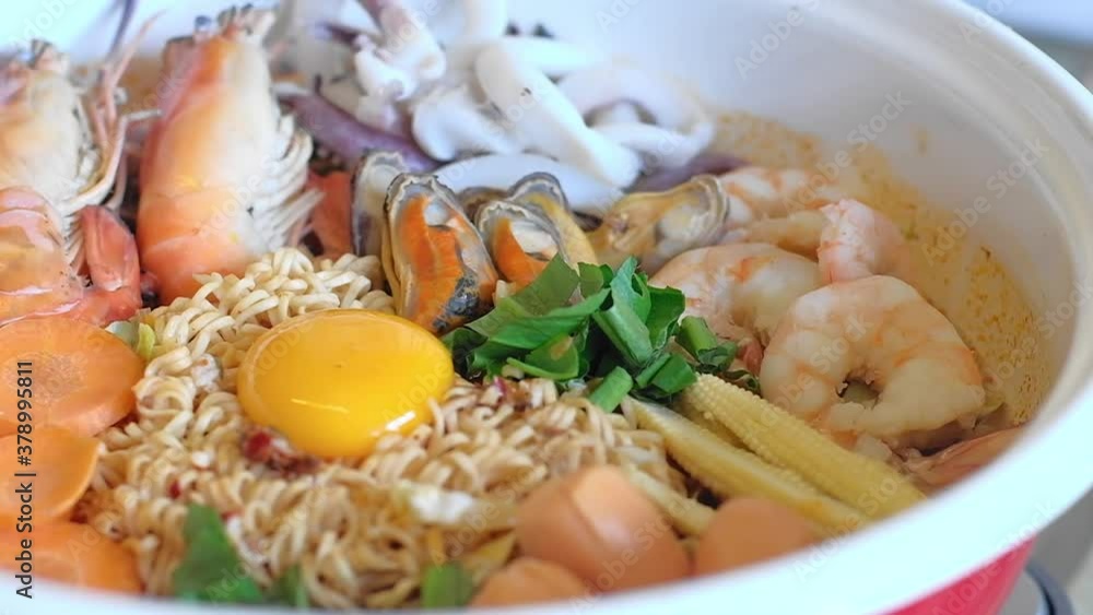 Yummy delicious instant noodles with seafood egg yolk and vegetables
