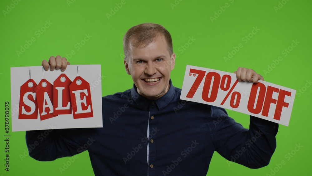 Cheerful man showing Sale word and showing Up To 70 percent Off inscription. Black Friday concept Cheerful man showing Sale word and showing Up To 70 percent Off inscription. Black Friday concept