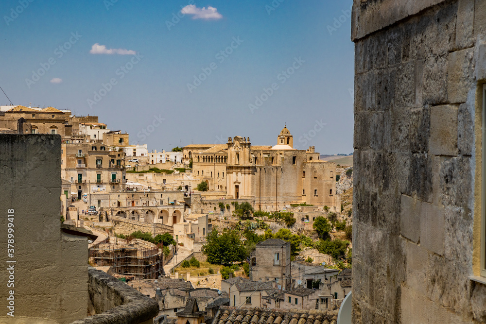 Matera, Basilicata, Italy - Panoramic view from the top of the Sassi of Matera, Barisano. The ancient houses of stone and brick, carved into the rock. The church of Sant'Agostino.