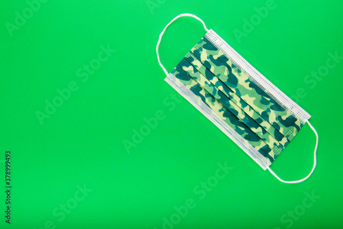 Camo surgical face mask as protection to covid 19 coronavirus photo