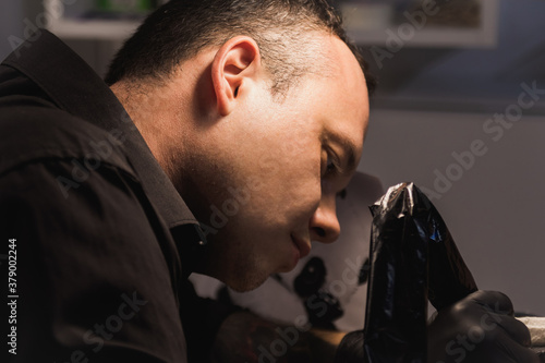 Close-up of the face of a tattoo artist at work