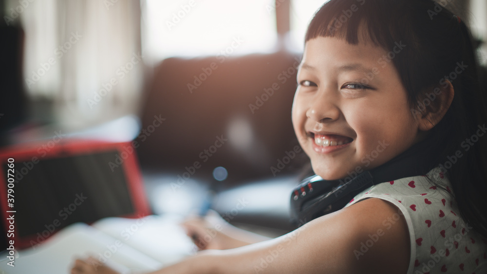 Smile little child girl learning on laptop at home,Social distance during quarantine, Online education concept Smile little child girl learning on laptop at home,Social distance during quarantine, Online education concept