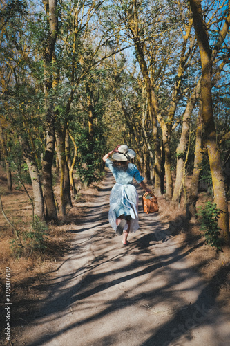 Girl in Vintage Dress Running in Savanna. Female traveler walking on a fall day in the beautiful natural park. © SemSay