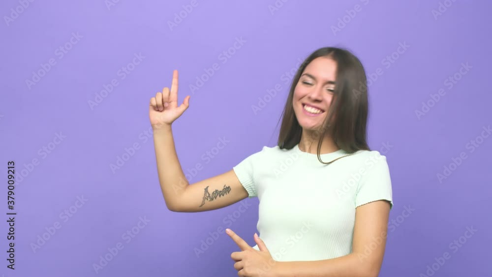 Young cute woman pointing with forefingers to a copy space, expressing excitement and desire Young cute woman pointing with forefingers to a copy space, expressing excitement and desire