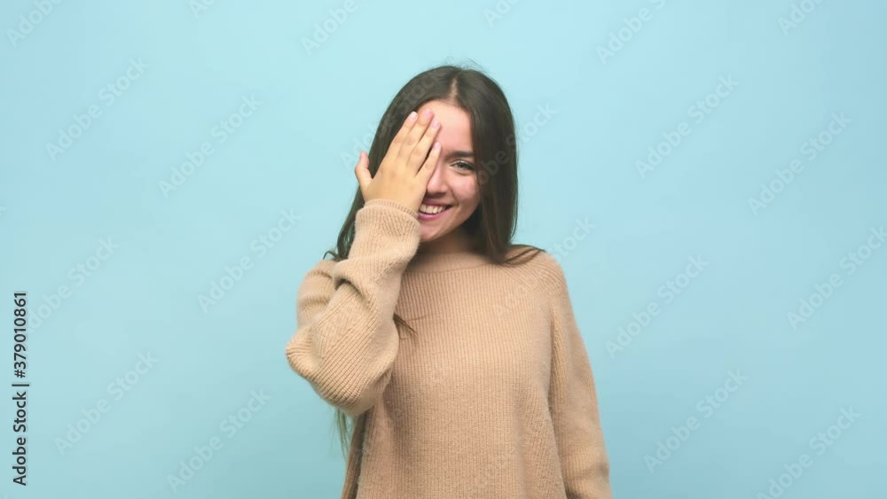 Young cute woman having fun covering half of face with palm Young cute woman having fun covering half of face with palm