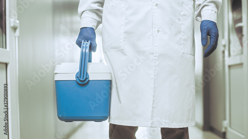 Medical worker, nurse, doctor holding a portable refrigerator bag.