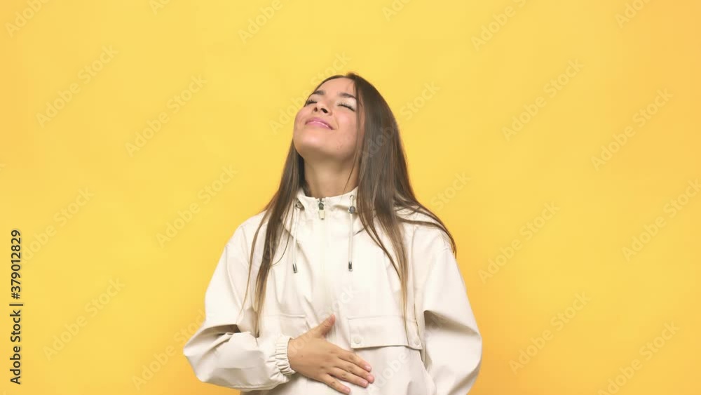 Young cute woman touches tummy, smiles gently, eating and satisfaction concept