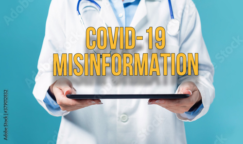 Covid-19 Misinformation theme with a doctor using a tablet computer photo