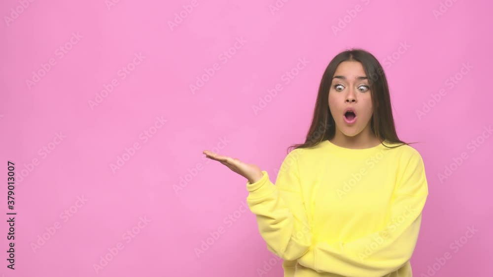 Young cute woman impressed holding copy space on palm Young cute woman impressed holding copy space on palm