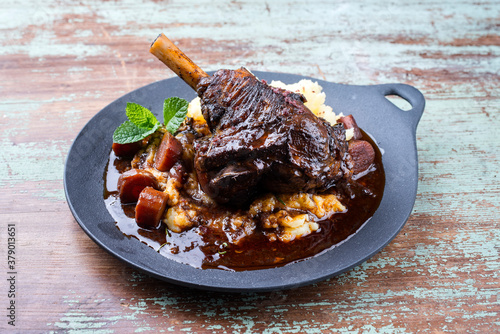 Modern Style traditionelle geschmorte Lammhaxen in Rotwein Sauce mit Schalotten und Kartoffelpüree angeboten als close-up in einem Design Teller photo