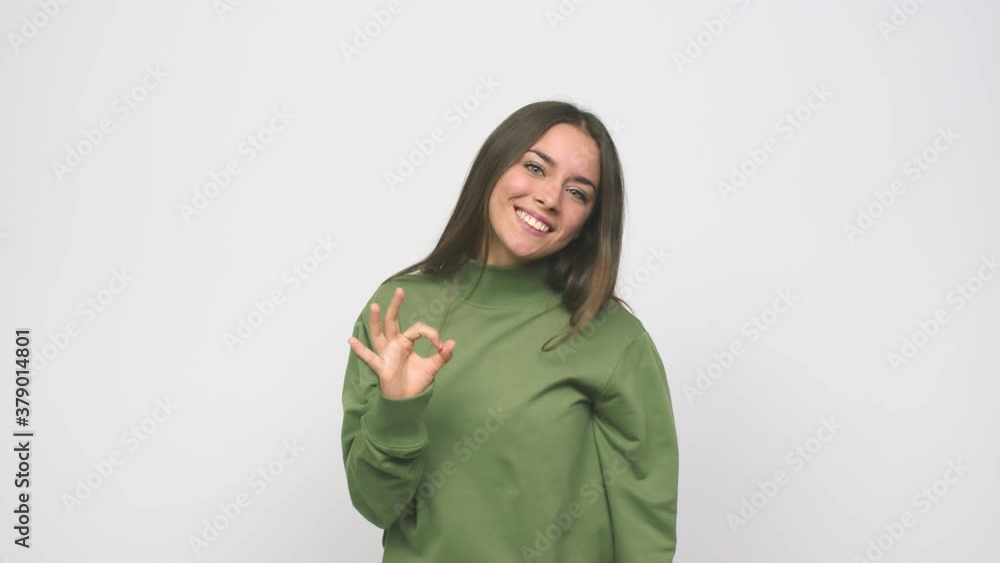 Young cute woman cheerful and confident showing ok gesture Young cute woman cheerful and confident showing ok gesture