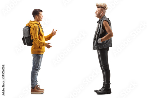 Full length profile shot of a teenager talking to a punk rocker with a mohawk
