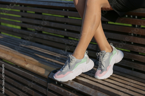 woman's legs in sport sneakers outdoor close up