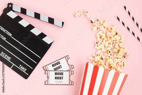 Fotografie Movie clapperboard, tickets and popcorn over pink background