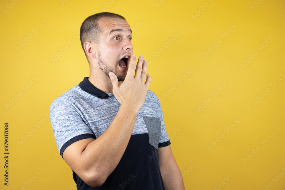 Russian man standing over insolated yellow background afraid and shocked with surprise expression, fear and excited face. Russian man standing over insolated yellow background afraid and shocked with surprise expression, fear and excited face.