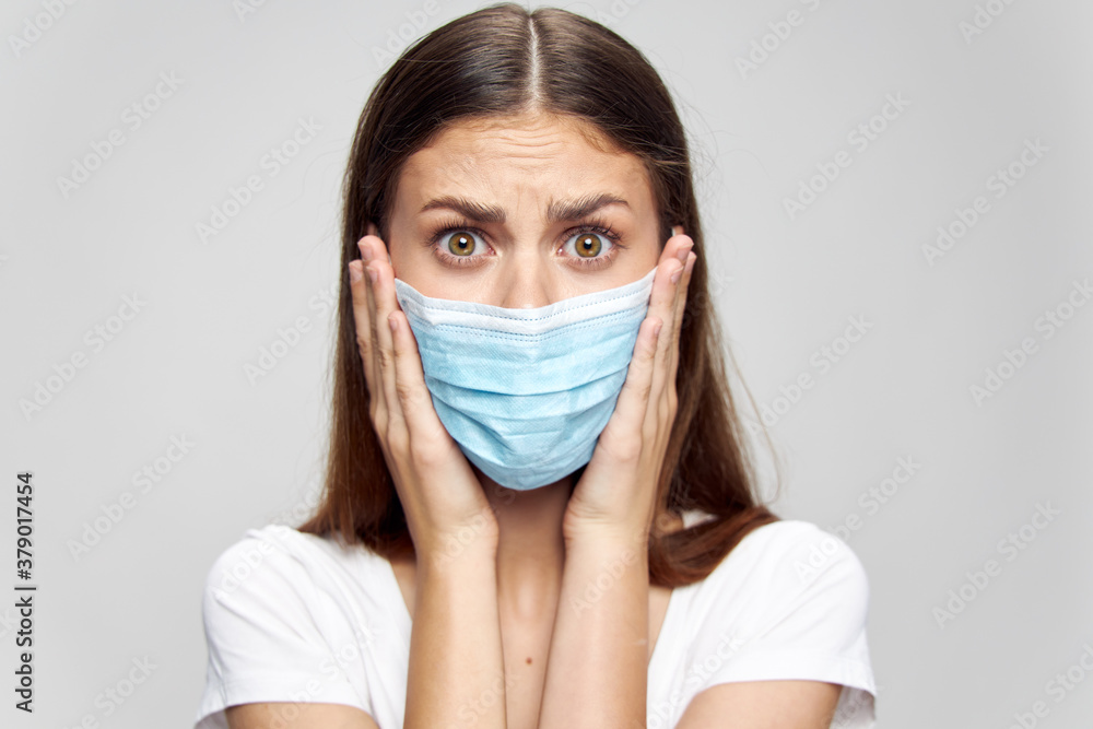 Surprised woman in medical mask touches face with hands Surprised woman in medical mask touches face with hands