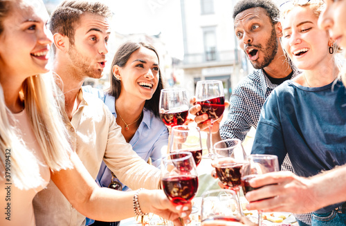 Happy multiracial friends having fun drinking and toasting red wine at lunch party - Young people eating bbq food at restaurant winery together - Dining lifestyle concept on bright warm filter