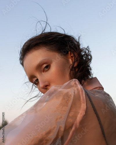 
Portrait of a girl in a pink blouse against the sky