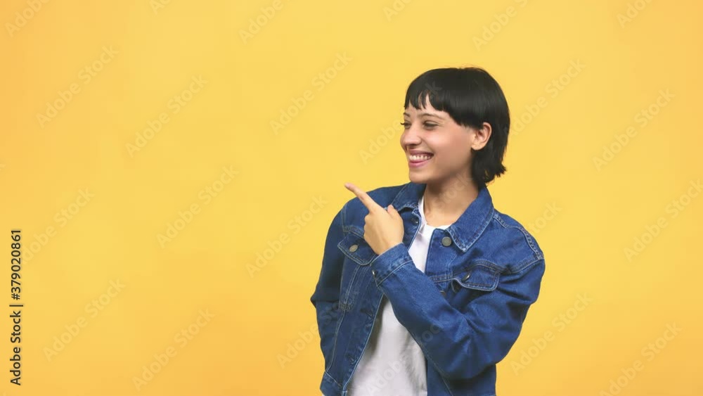 Young caucasian woman pointing to the side, smiling surprised presenting something, natural and casual Young caucasian woman pointing to the side, smiling surprised presenting something, natural and casual