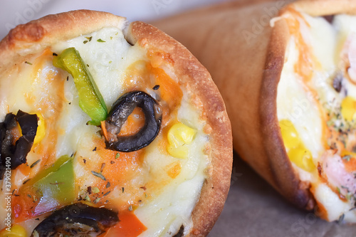 Organics and delicious pizza cones with a crunchy thin crust, lots of melted cheese, fresh vegetables and fine spices. photo