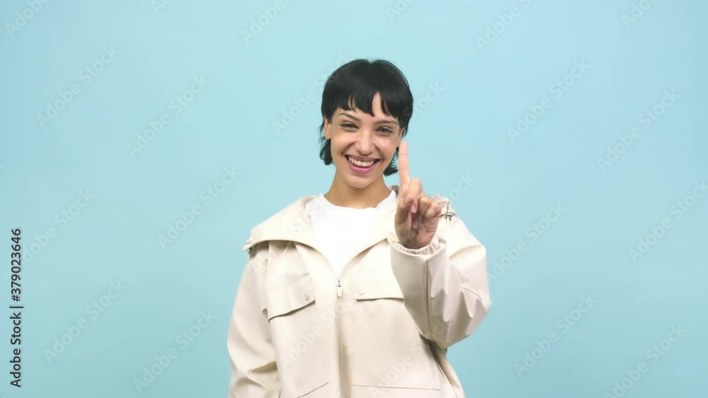 Young caucasian woman showing number one, symbol of counting, concept of mathematics, confident and cheerful Young caucasian woman showing number one, symbol of counting, concept of mathematics, confident and cheerful