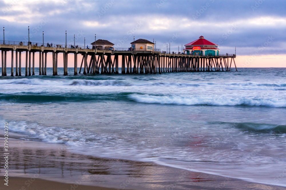 Seascape of the Huntington Beach pier at sunset, with slow shutter speed. 