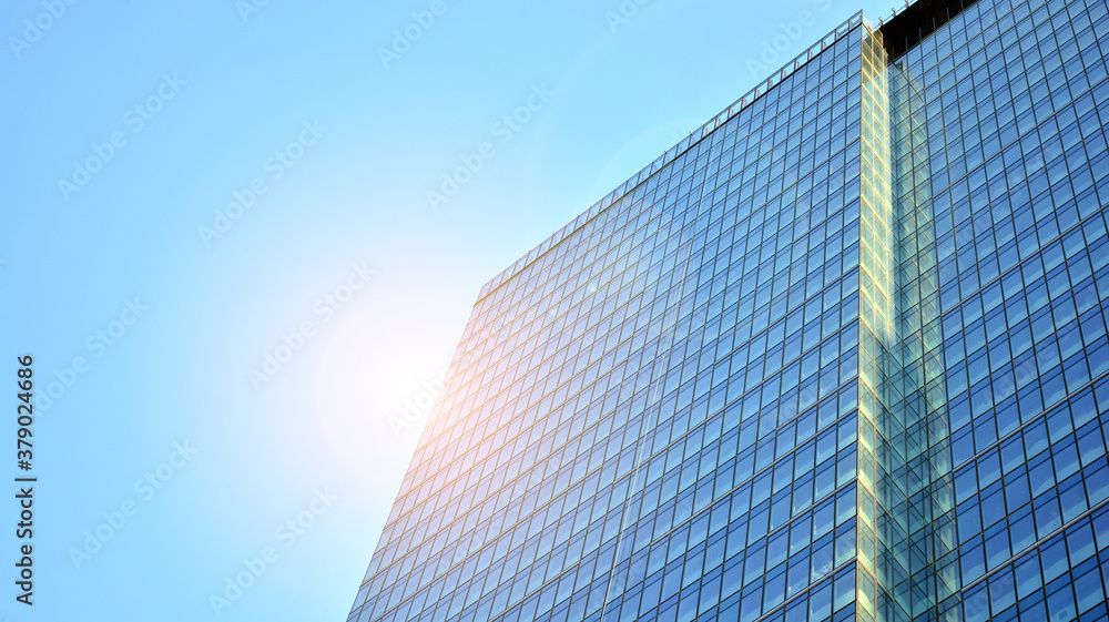 Office building, details of blue glass wall and sun reflections.