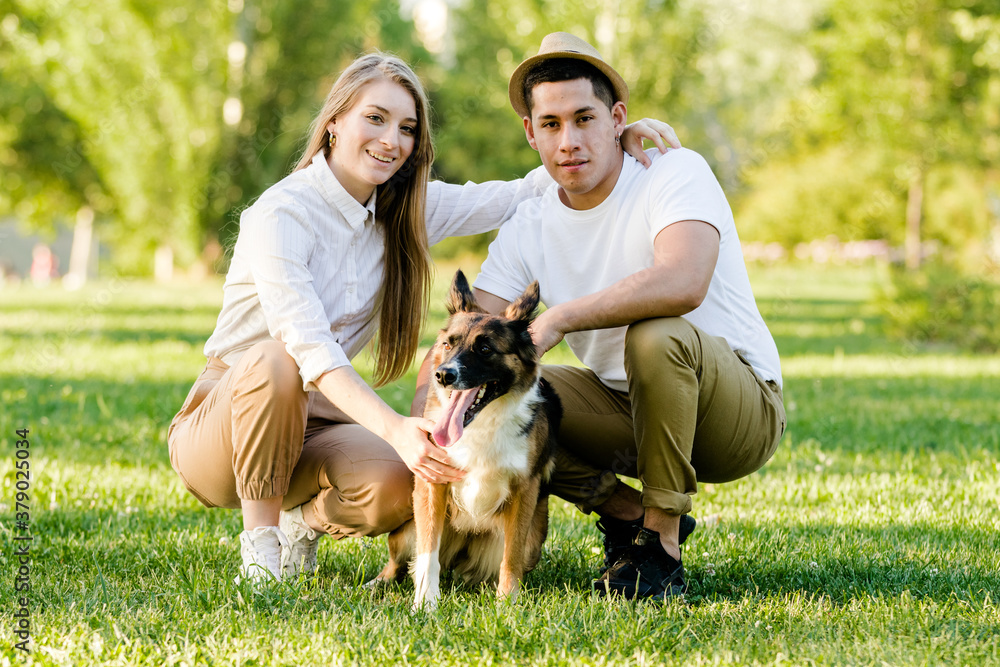 Lovely couple with their dog having fun in the park