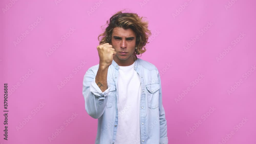 Young cool australian man showing fist to camera, aggressive facial expression