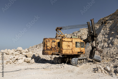 Wallpaper Mural A large yellow tracked excavator is mining rock in a quarry. Torontodigital.ca
