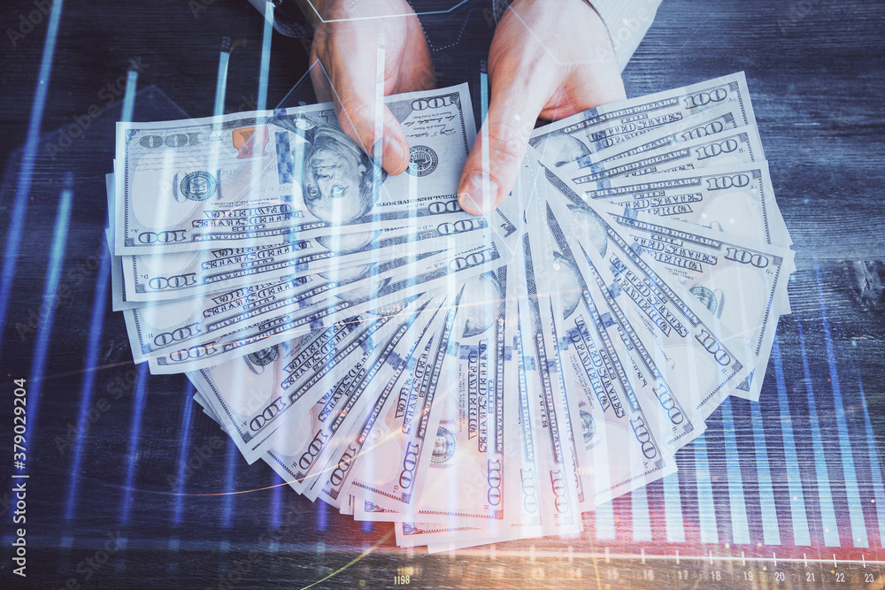 Multi exposure of financial graph drawing hologram and USA dollars bills and man hands. Analysis concept. Multi exposure of financial graph drawing hologram and USA dollars bills and man hands. Analysis concept.