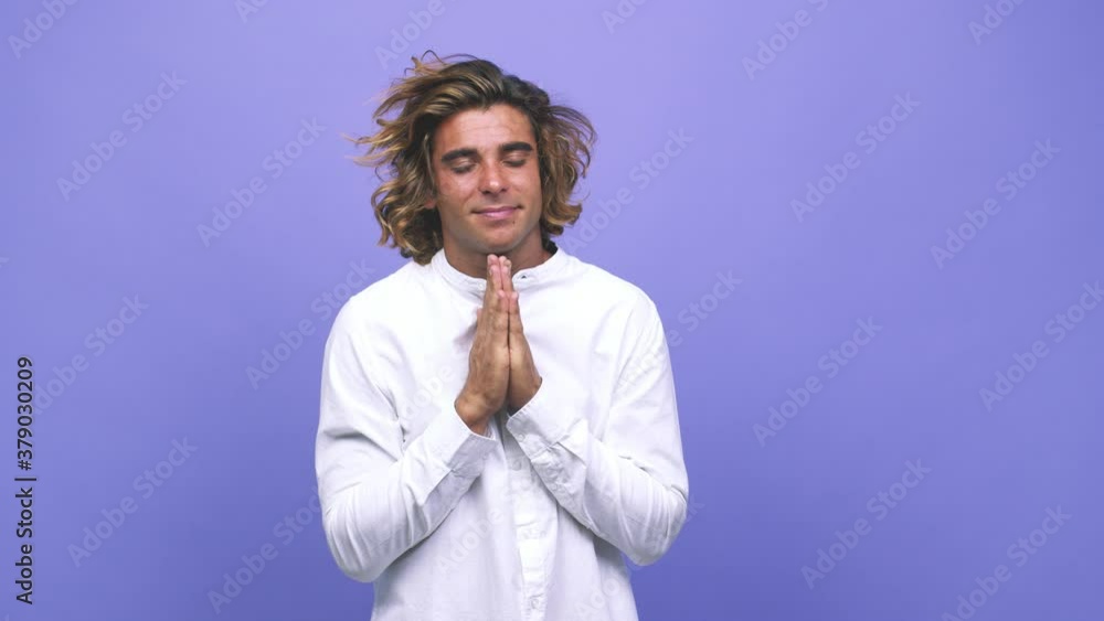 Young cool australian man holding hands in pray near mouth, feels confident Young cool australian man holding hands in pray near mouth, feels confident
