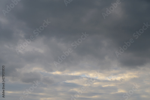 Abstract background of gray fluffy clouds on a bright blue sky