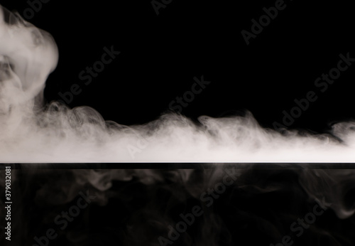 White smoke swirling spreads over the surface flowing down from the edges on a black background © Александр 