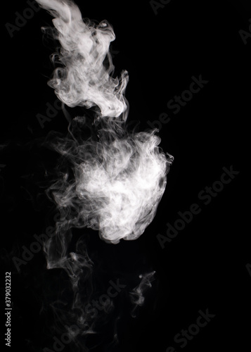 Descending stream of white smoke swirls chaotically in whimsical patterns on a black background © Александр 