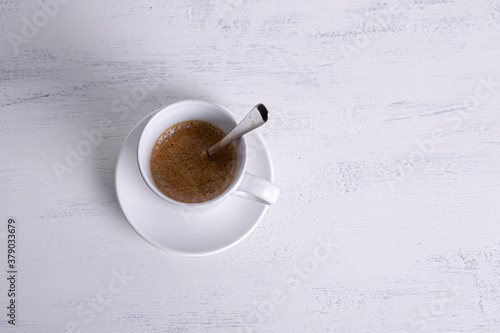cup of coffee with artisan cookies on white wooden background