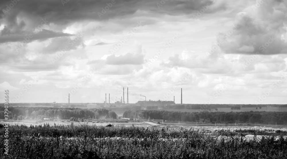 Φωτογραφία Silhouette of a factory on the horizon with smoking chimneys and surrounding fie