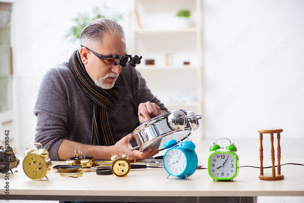 Φωτογραφία Old male watchmaker working in the workshop