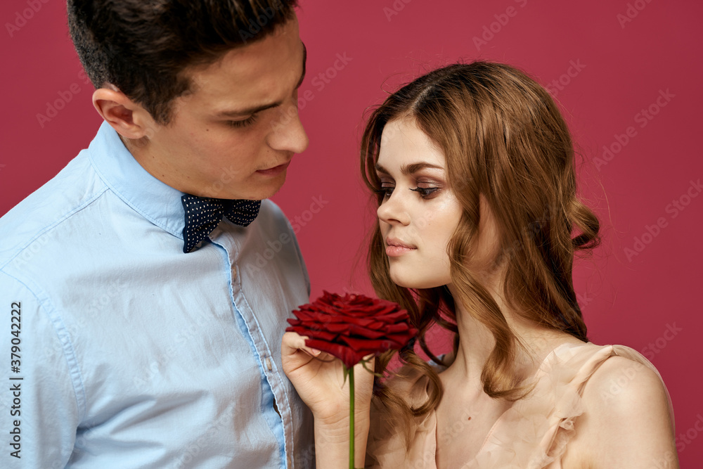 Naklejka premium portrait of romantic couple in love with red rose on isolated background and classic suit evening dress