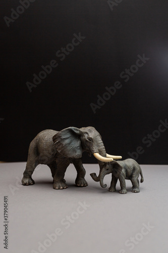 Toy figurine of an elephant and baby elephant on a black background. Wildlife  zoo
