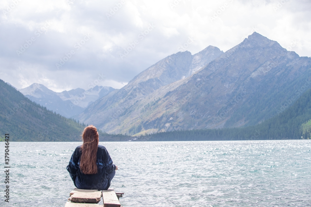 Young woman enjoys the view of the Multinsky lake. Empty space for text Young woman enjoys the view of the Multinsky lake. Empty space for text