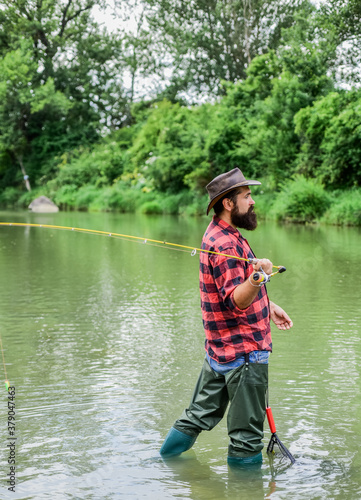 bearded fisher in water. fisherman with fishing rod. mature man fly fishing. man catching fish. hobby and sport activity. pothunter. summer weekend. Big game fishing. surrender your business