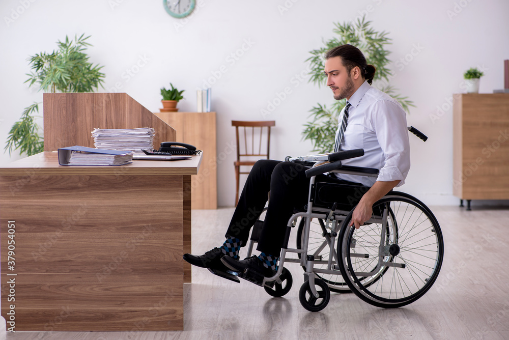 Young disabled employee suffering at workplace Young disabled employee suffering at workplace